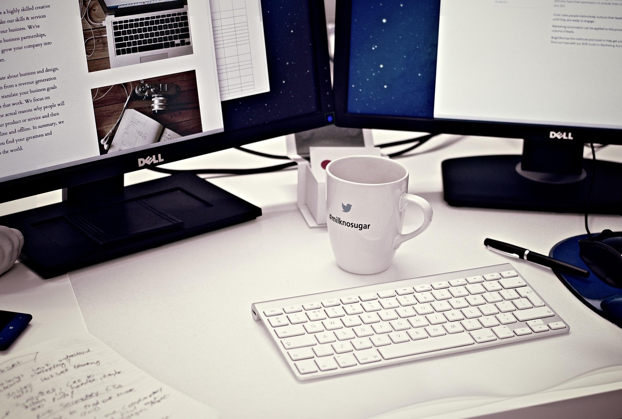 Twee monitoren met multitaskende professional.