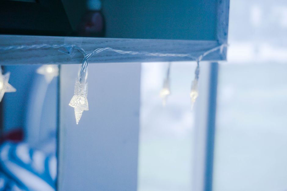 Luchtige lichtgrijze gordijnen in zonnige slaapkamer.